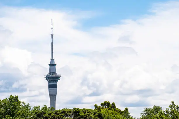 2017, DEC 4 - Auckland, New Zealand - Skytower over the green trees with clouds and blue sky.