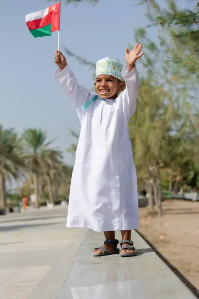 Cute Omani boy is playing outside near the beach