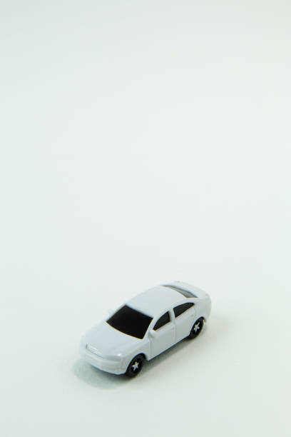 istock white car toy and gold coin on  white background. 1060850400
