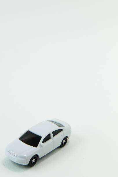 istock white car toy and gold coin on  white background. 1060850410
