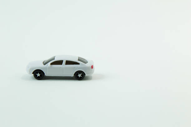 istock white car toy and gold coin on  white background. 1060850436
