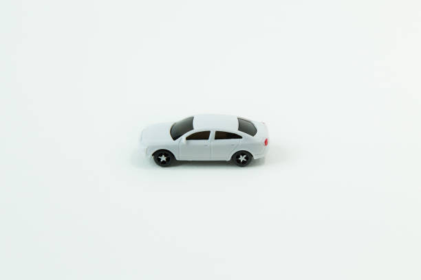 istock white car toy and gold coin on  white background. 1060850490
