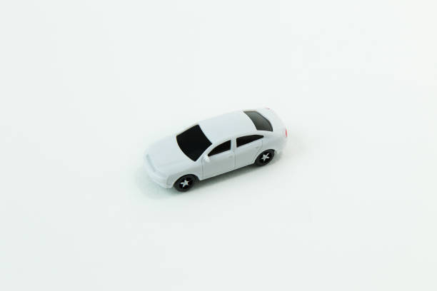 istock white car toy and gold coin on  white background. 1060850528