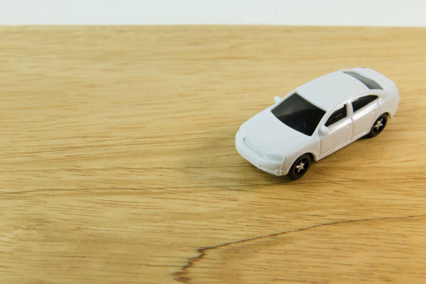 istock white car toy on wood table  image close up. 1060850680