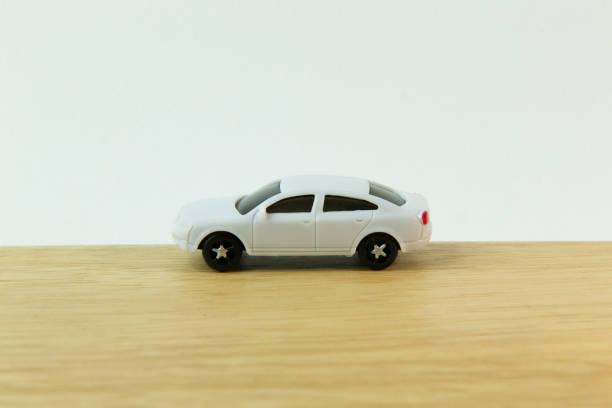 istock white car toy on wood table  image close up. 1060850830