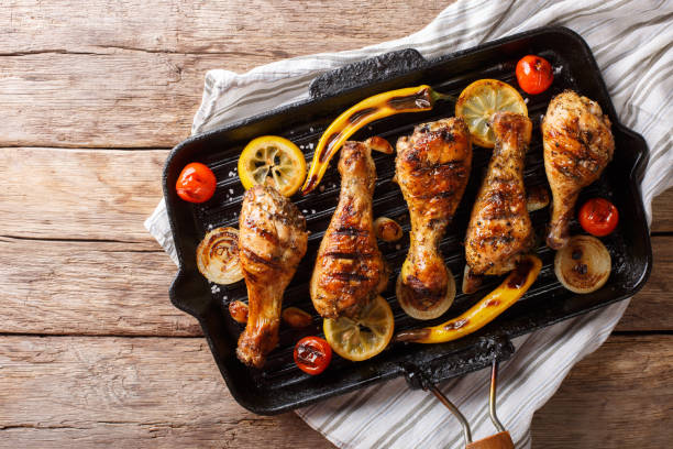 istock Freshly cooked grilled chicken drumstick legs with vegetables in a grill pan close-up. horizontal top view 1060858608
