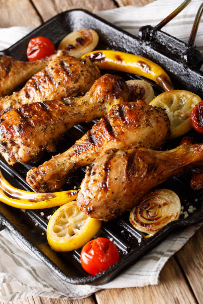 istock Fried chicken drumstick with vegetables in a grill pan close-up. vertical 1060858662