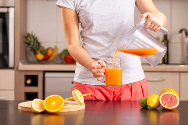 istock Woman pouring freshly squeezed juice into a jar 1060859416