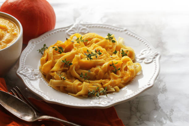 istock Tagliatelle pasta with pumpkin cream sauce over black background 1060861218