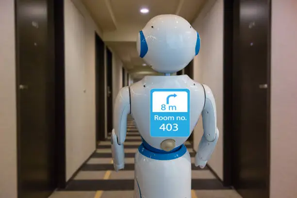 Photo of smart hotel in hospitality industry 4.0 technology concept, robot butler (robot assistant) use for greet arriving guests, deliver customer, items to rooms, give information, support  variety languages