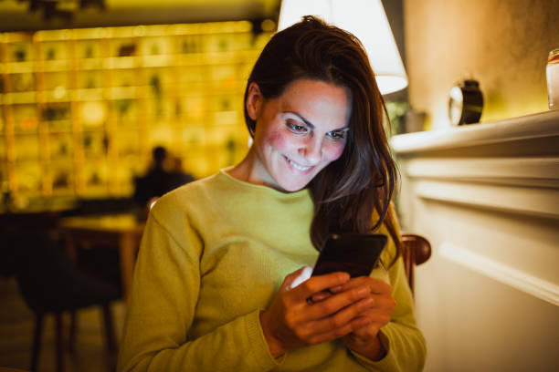 istock Young woman enjoying coffee break in cafe, using smart phone 1060863296
