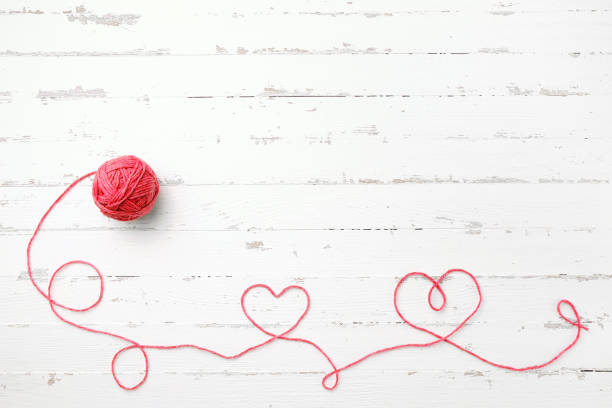 красная нить, два сердца и клубок - wool knitting heart shape thread стоковые фото и изображения