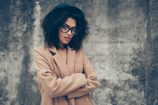 Portrait of she her nice cute magnificent confident mysterious attractive well-groomed curly-haired lady wearing modern urban outfit spring season timeless beige color