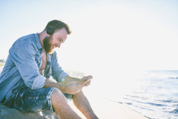istock Handsome Bearded Male Is Making Video Call On Cuban Beach 1060872482