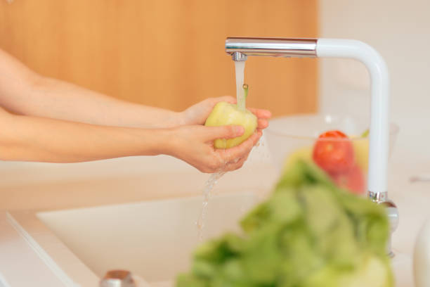 istock Hands Washing Yellow Pepper in Kitchen Sink 1060877394