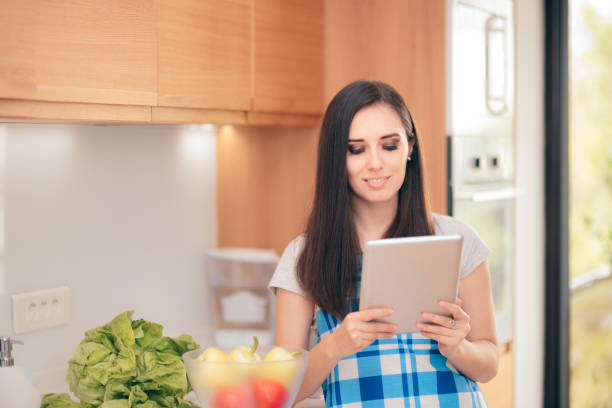istock Woman Holding Tablet Pc Looking for Recipes Online 1060877476