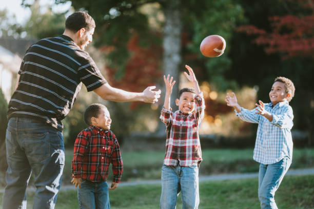 istock Father Plays Football Outside With His Sons 1060879476