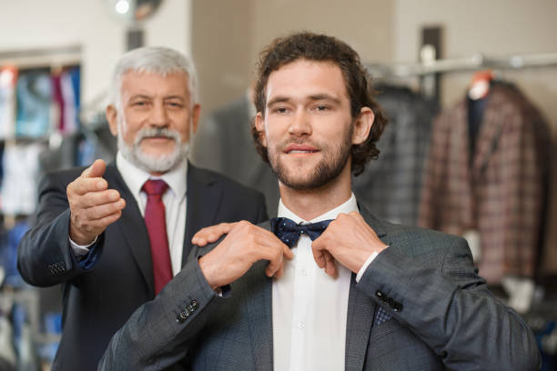 istock Two happy atractive elegant men choosing clothes for special occaision. 1060879798