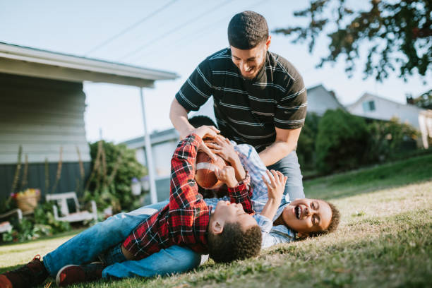 Father Plays Football Outside With His Sons