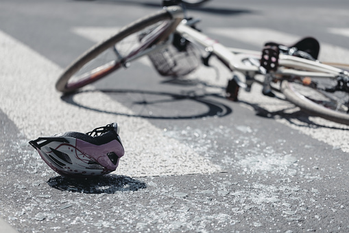 Closeup de casco y bicicleta en una líneas peatonales después de incidente de peligro con un coche para niños photo