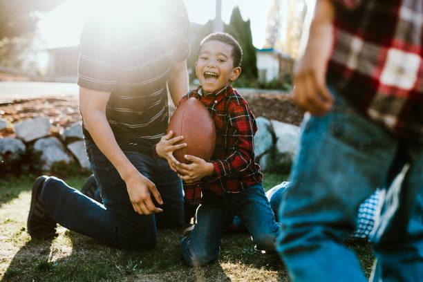 istock Father Plays Football Outside With His Sons 1060880136