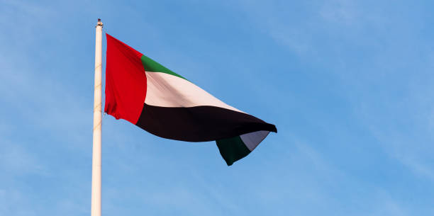 istock United Arab Emirates flag against blue sky 1060883220