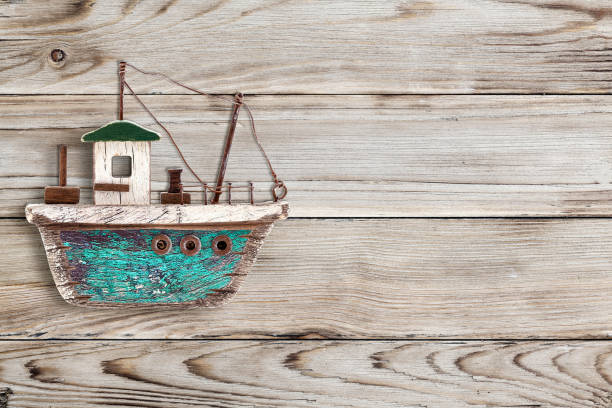 istock Toy sailboat on a wooden background 1060886858