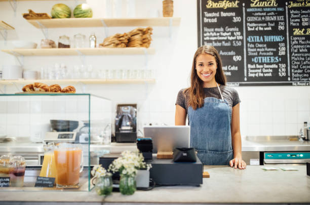 istock Confident female barista standing behind cafe counter 1060887050
