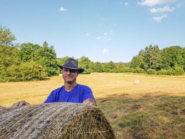 istock A farmer in a hat stands at a stack of fresh hay 1060890030