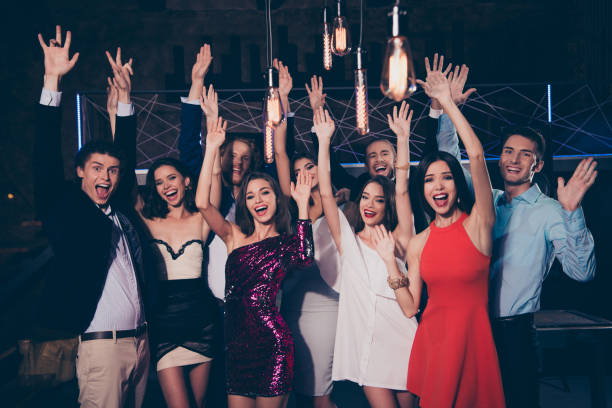 Beautiful nice funky attractive cool bright vivid shiny elegant cheerful glad excited classy stylish trendy ladies and gentlemen at cocktail party, chill out at night club, raising hands up