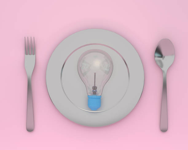 istock Creative idea layout made of light bulbs glowing on plate with spoons and forks on pink color background. minimal healthcare concept. 1060895742