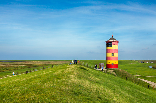 Pilsum, Germany - September 17, 2018: Tourists visiting Pilsum lighhouse on the North Sea coast in East Frisia.