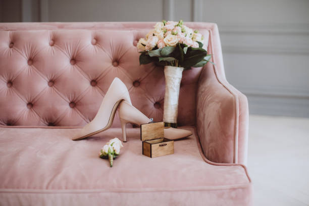 bouquet nuziale con scarpe da sposa e fedi nuziali su un divano vintage - wedding venue foto e immagini stock