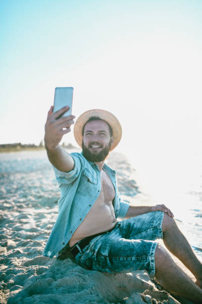 istock Handsome Bearded Male Is Taking A Selfie On An Empty Cuban Beach 1060907126