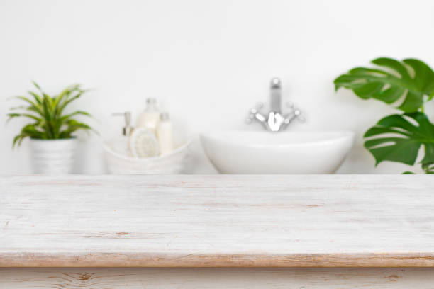 istock Wooden table top over blurred bathroom interior and spa products 1060909582