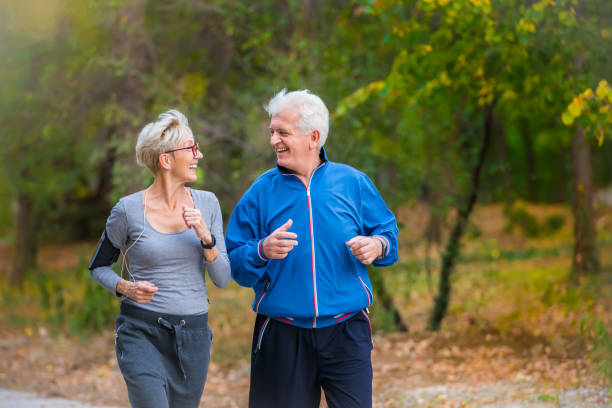 istock Smiling senior couple jogging in the park 1060917528