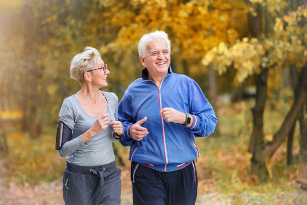 istock Smiling senior couple jogging in the park 1060917554