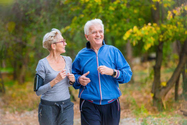 istock Smiling senior couple jogging in the park 1060917752