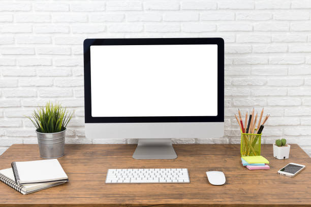 istock workspace with computer with blank white screen, and office supplies on a wooden desk 1060917876
