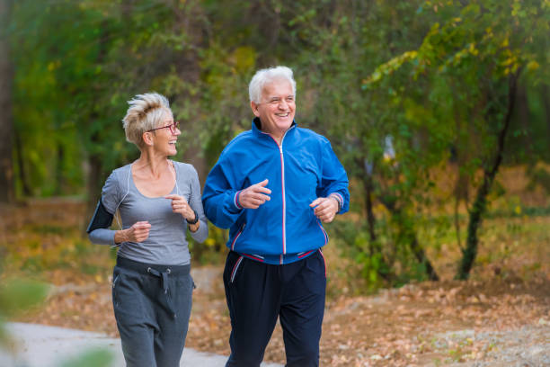 istock Smiling senior couple jogging in the park 1060918016