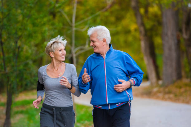 istock Smiling senior couple jogging in the park 1060918224