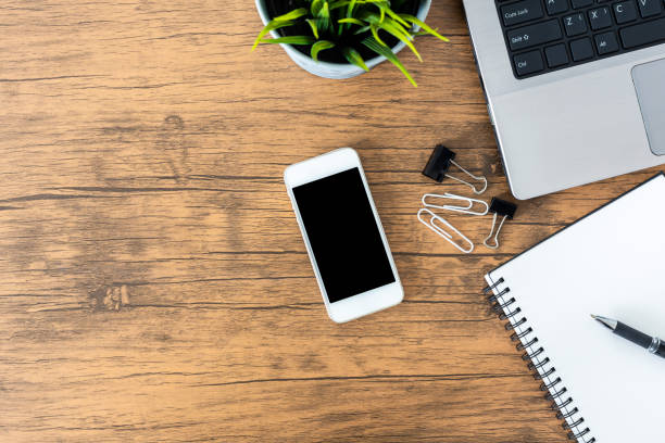 istock office desk with smartphone blank screen, computer and office supplies top view 1060918272