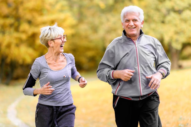 istock Smiling senior couple jogging in the park 1060918312