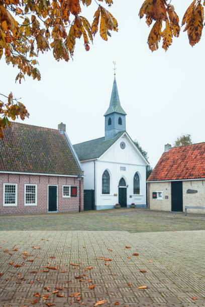 die front der weißen kirche in bourtange, ein niederländischer befestigte dorf in der provinz groningen - autumn clock roof colors stock-fotos und bilder