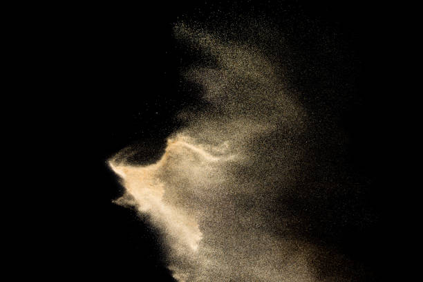 istock Golden sand explosion isolated on black background. Abstract sand cloud. 1060927058