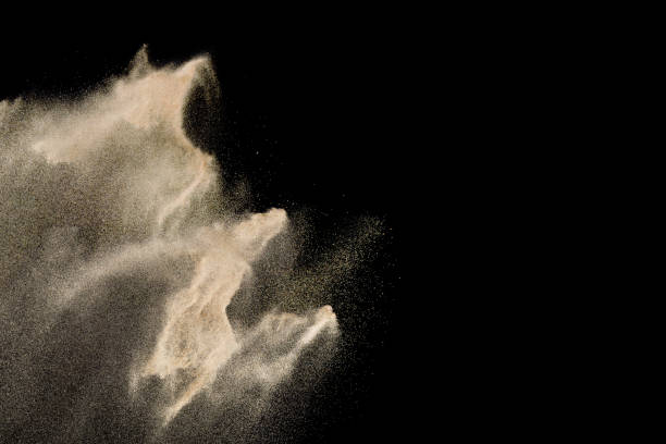 istock Golden sand explosion isolated on black background. Abstract sand cloud. 1060927124