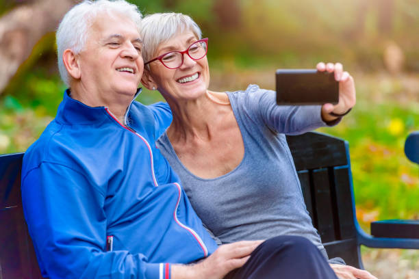 istock Smiling senior couple in the park taking selfie 1060928470