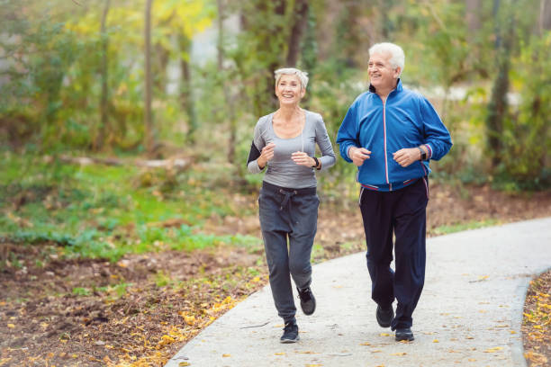 Smiling senior couple jogging in the park Senior active couple running, walking and talking in the park. Healthy lifestyle pedometer photos stock pictures, royalty-free photos & images