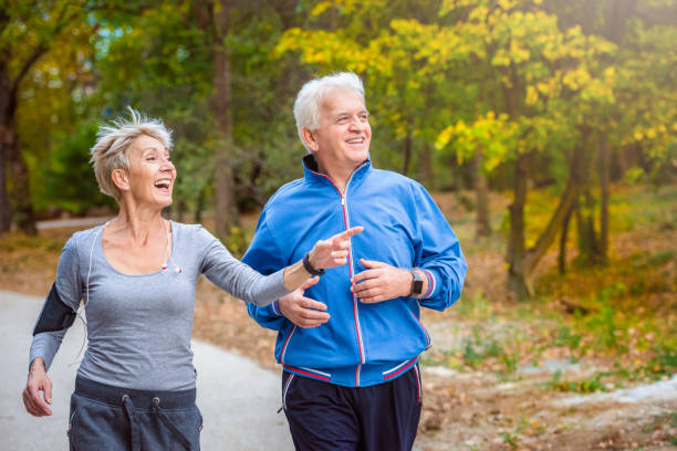 istock Smiling senior couple jogging in the park 1060930638