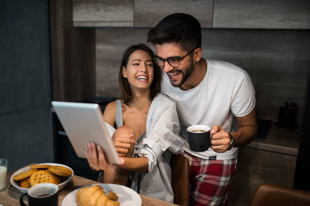 istock Young couple at home using tablet and smartphone - Morning breakfast time 1060936742